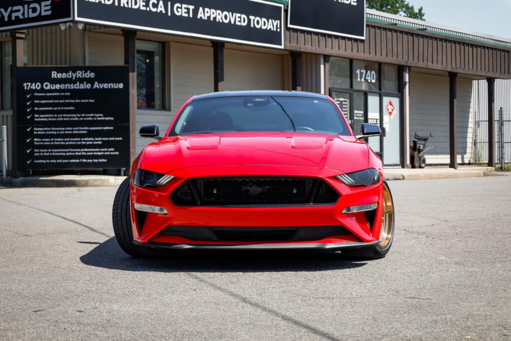 Red Ford Mustang in front of the Ready Ride Ottawa showroom